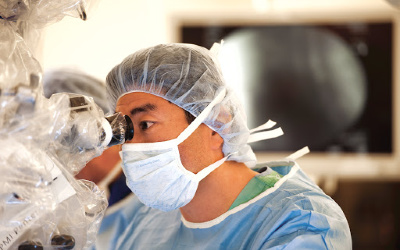 Kee Kim, M.D. at the surgical microscope